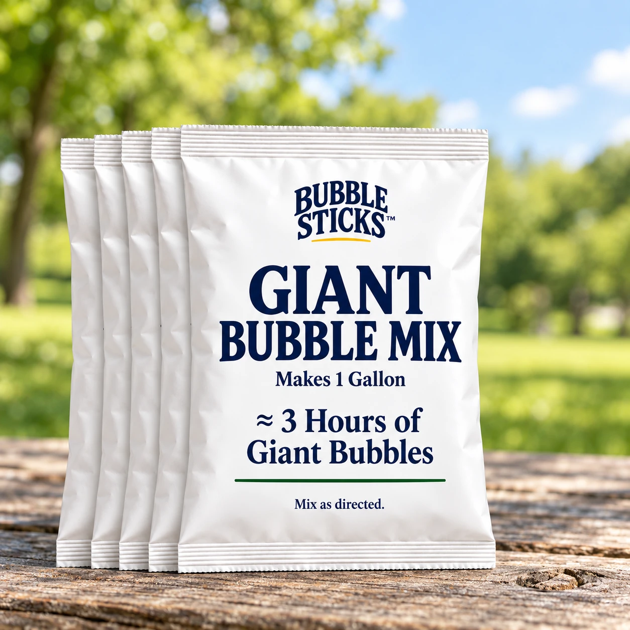 5 sealed white Bubble Sticks giant bubble mix refill pouches in compact stacks on a park picnic table